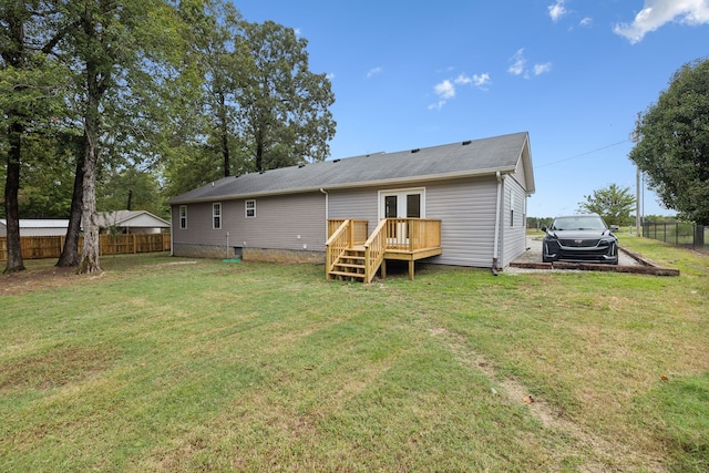 rear view of property with a lawn, french doors, and a deck