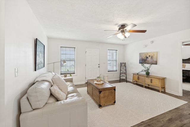 living room featuring a textured ceiling, light hardwood / wood-style floors, a wealth of natural light, and ceiling fan