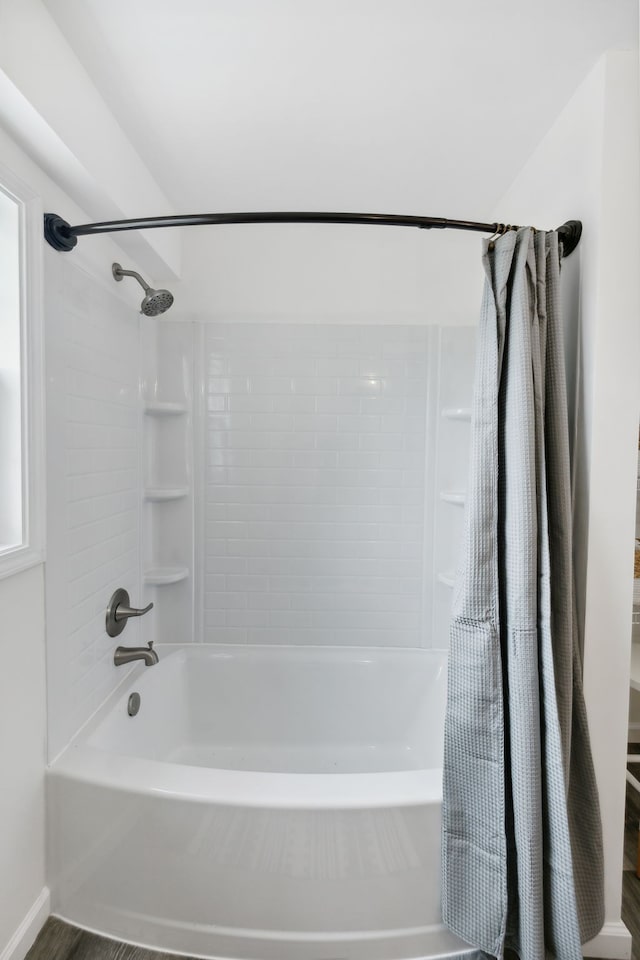 bathroom with hardwood / wood-style floors and shower / tub combo with curtain