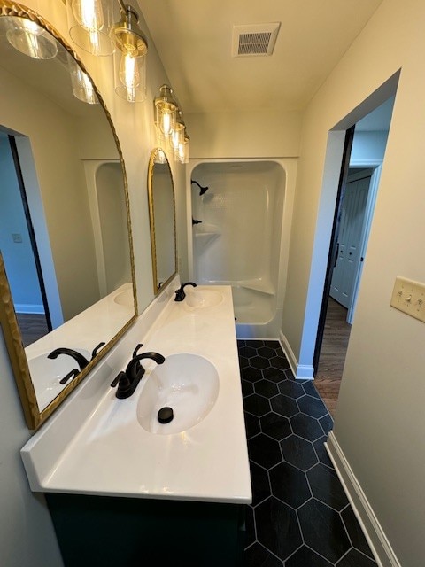 bathroom featuring tile patterned floors, vanity, and walk in shower