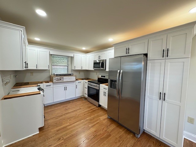 kitchen featuring white cabinets, light hardwood / wood-style floors, and appliances with stainless steel finishes