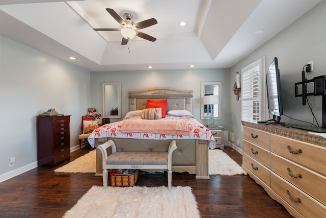 bedroom featuring a tray ceiling, ceiling fan, and dark wood-type flooring