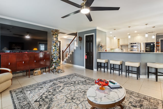 tiled living room featuring ceiling fan, crown molding, and sink