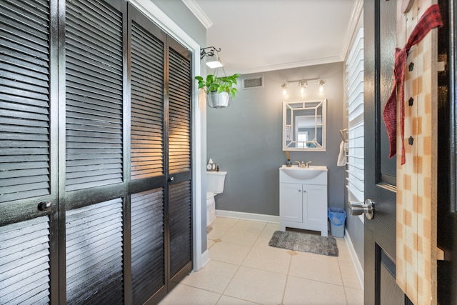 bathroom featuring tile patterned flooring, vanity, toilet, and crown molding