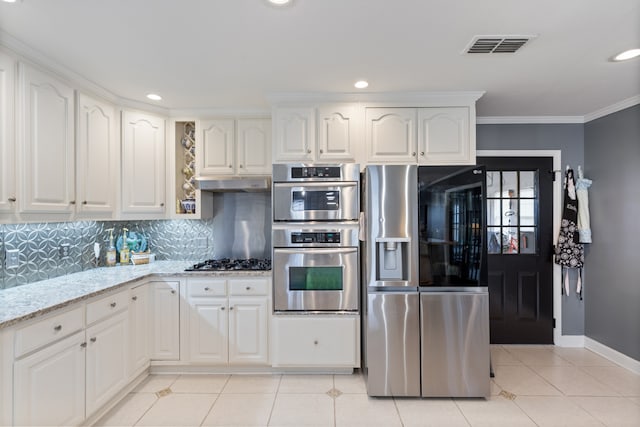 kitchen with white cabinetry, light stone countertops, tasteful backsplash, appliances with stainless steel finishes, and ornamental molding