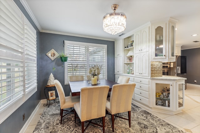 dining area with plenty of natural light, light tile patterned flooring, ornamental molding, and a chandelier