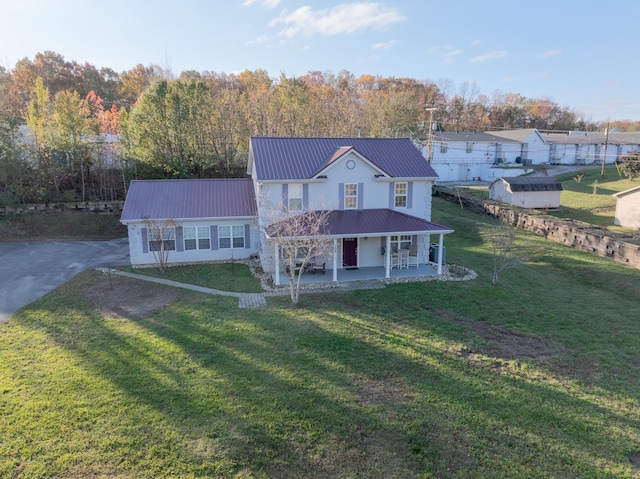 farmhouse featuring covered porch and a front lawn