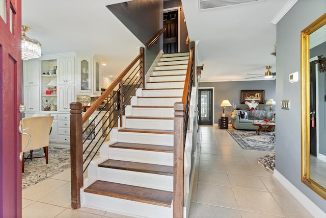 staircase with tile patterned flooring and ornamental molding