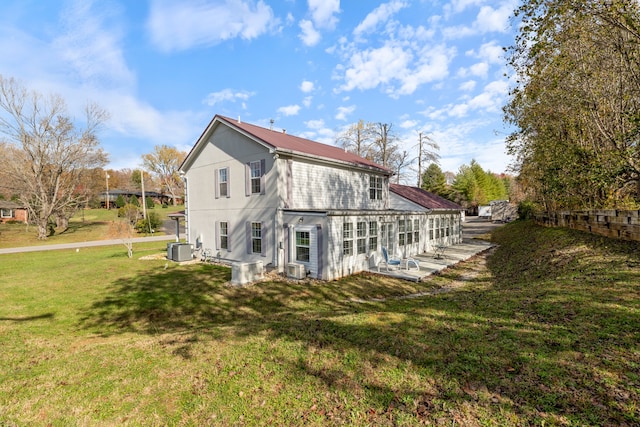 back of house with a lawn, central air condition unit, and a patio