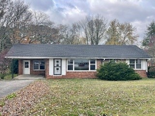 single story home featuring a carport and a front lawn