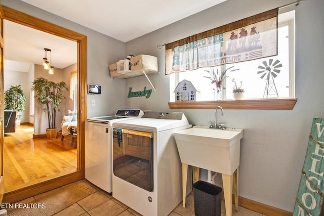 clothes washing area featuring washing machine and clothes dryer and light hardwood / wood-style flooring