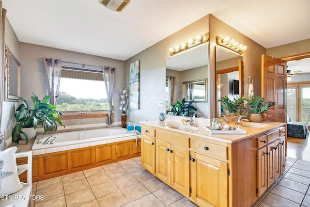 bathroom featuring tile patterned flooring, vanity, and a bath