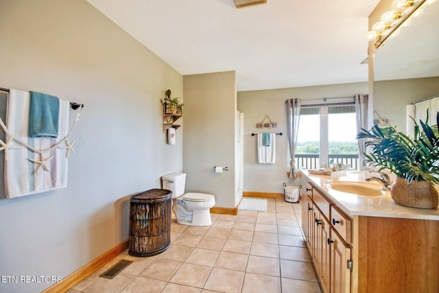 bathroom with tile patterned flooring, vanity, toilet, and vaulted ceiling