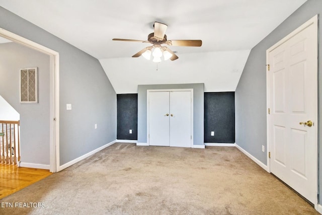 unfurnished bedroom with ceiling fan, light colored carpet, and lofted ceiling