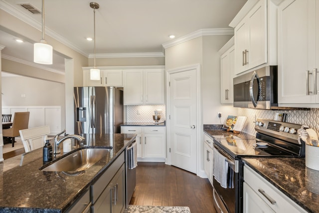 kitchen with sink, dark hardwood / wood-style floors, pendant lighting, white cabinets, and appliances with stainless steel finishes