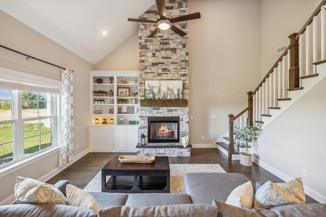 living room featuring ceiling fan, dark hardwood / wood-style flooring, a fireplace, and high vaulted ceiling