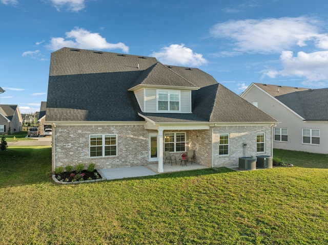 rear view of house featuring a lawn, central AC, and a patio