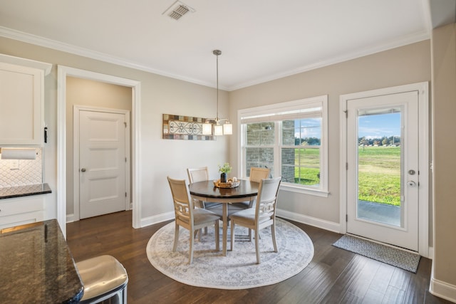 dining space featuring dark hardwood / wood-style flooring, an inviting chandelier, and ornamental molding