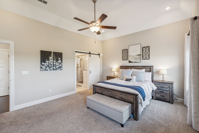 carpeted bedroom with connected bathroom, a barn door, and ceiling fan