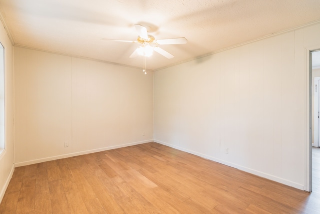 empty room with ceiling fan, ornamental molding, a textured ceiling, and light wood-type flooring