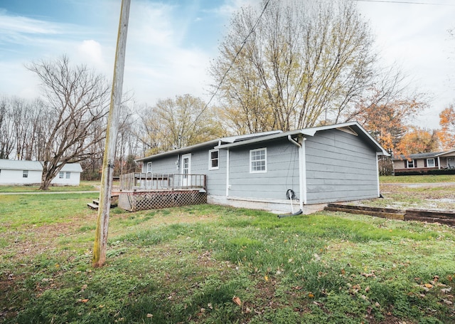 back of house featuring a deck and a lawn