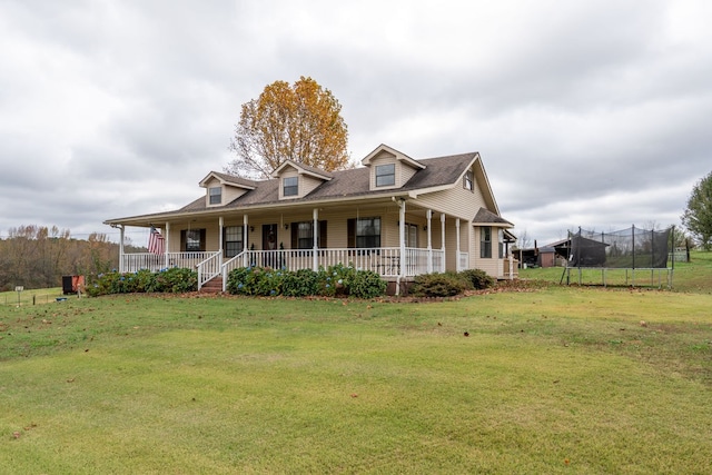 view of front of house featuring a front yard, a porch, and a trampoline