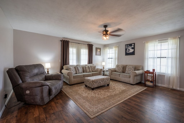 living room featuring dark hardwood / wood-style floors, ceiling fan, and a textured ceiling