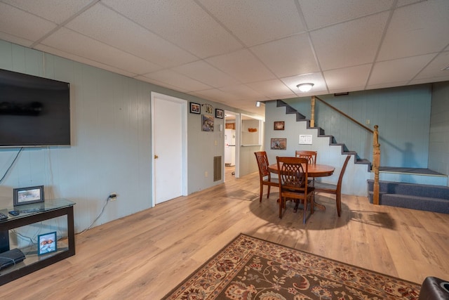 dining space with a paneled ceiling and hardwood / wood-style flooring