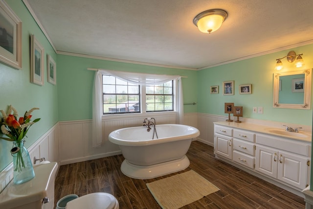 bathroom with hardwood / wood-style floors, a washtub, ornamental molding, and vanity