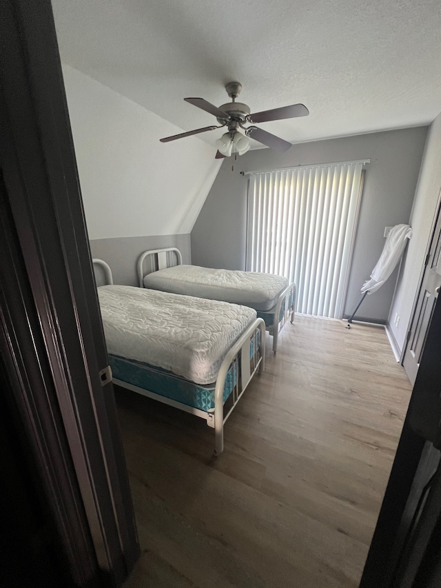 bedroom featuring ceiling fan, light hardwood / wood-style floors, and a textured ceiling