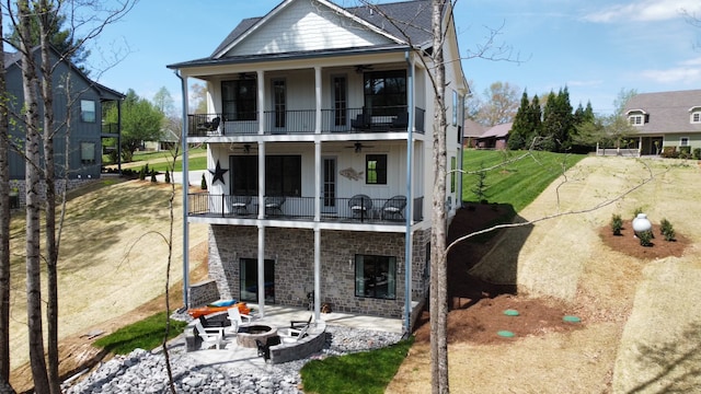 rear view of house featuring an outdoor fire pit, a patio area, a balcony, and ceiling fan