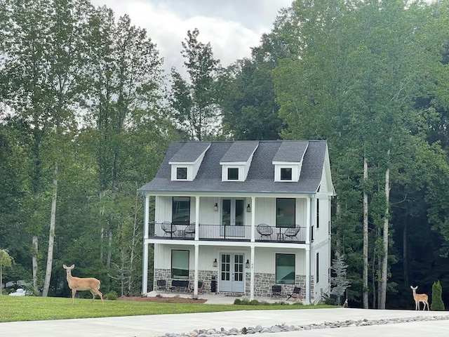 view of front facade with a balcony and french doors