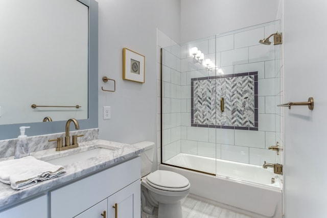 full bathroom with toilet, bath / shower combo with glass door, and vanity