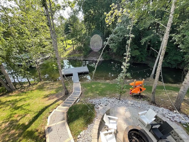 view of yard with an outdoor fire pit, a dock, and a water view