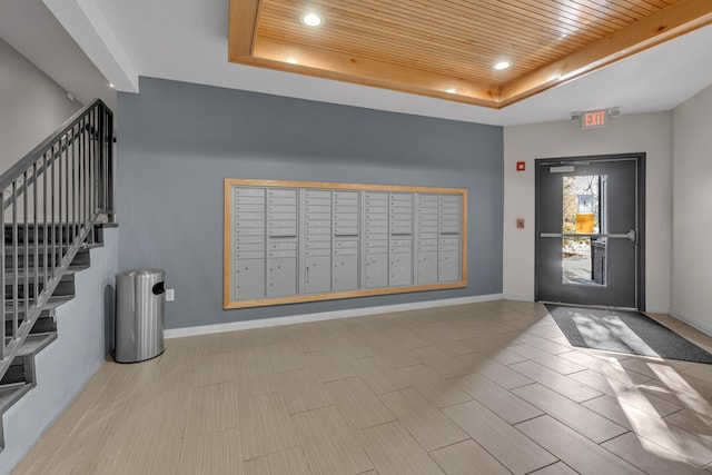 foyer with a tray ceiling, baseboards, and wooden ceiling