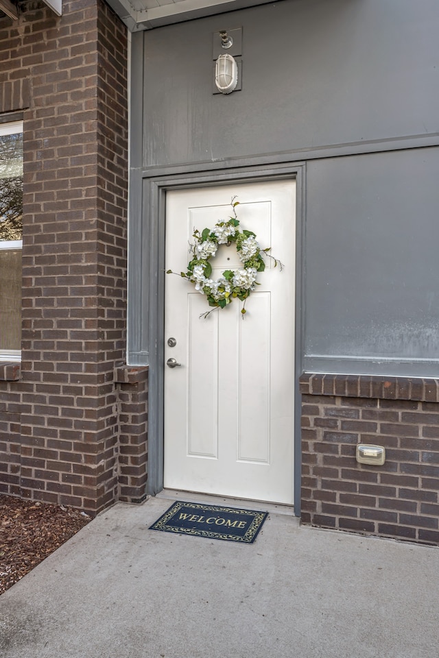 property entrance featuring brick siding