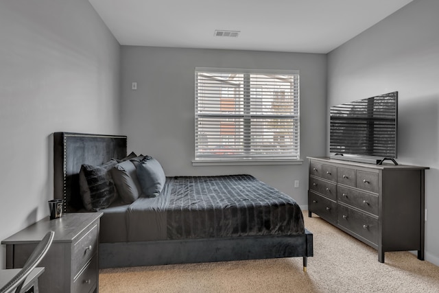 bedroom featuring baseboards, visible vents, and light carpet