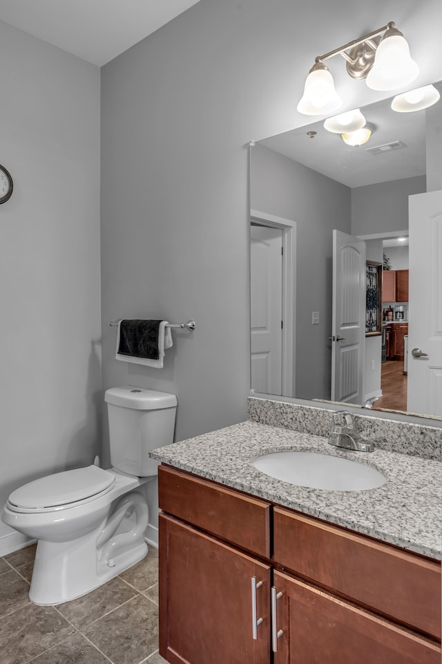 bathroom featuring tile patterned flooring, visible vents, baseboards, toilet, and vanity