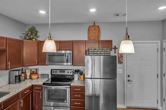 kitchen with light stone countertops, decorative backsplash, stainless steel appliances, and decorative light fixtures