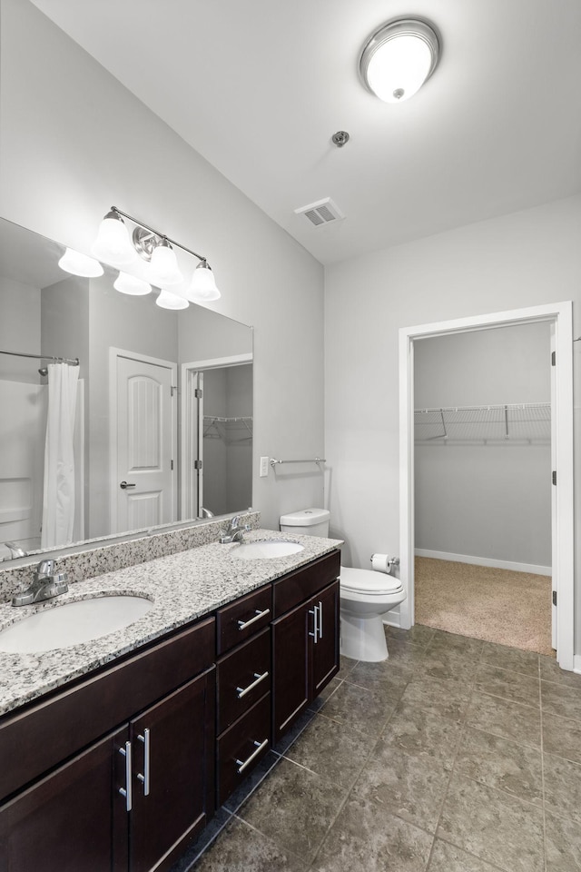 full bathroom featuring a sink, visible vents, toilet, and double vanity