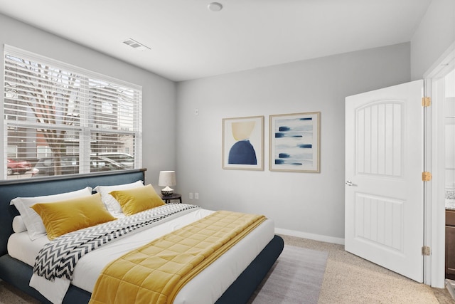 bedroom with light carpet, visible vents, and baseboards