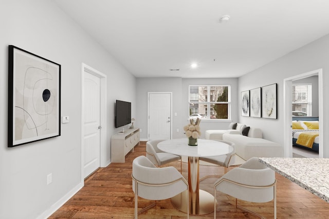 dining area featuring recessed lighting, wood finished floors, and baseboards