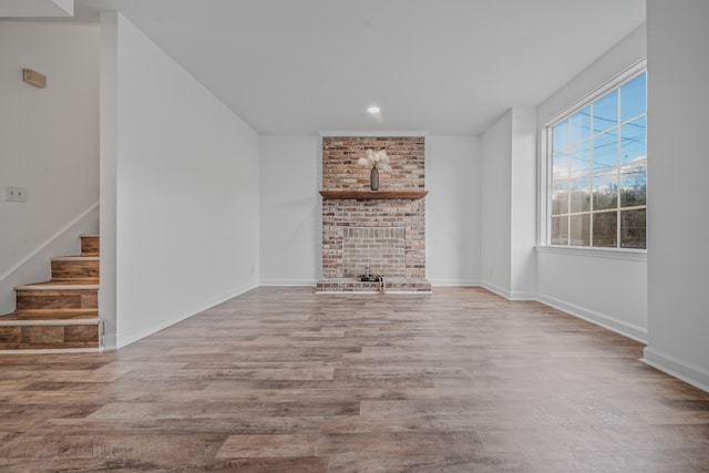 unfurnished living room with a fireplace and light hardwood / wood-style floors