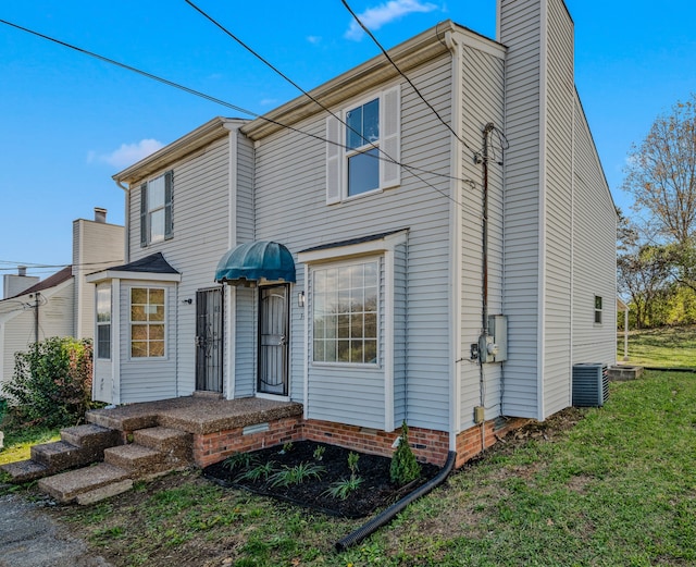 view of front facade with central AC unit and a front yard