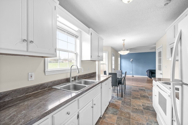 kitchen featuring sink, white cabinets, hanging light fixtures, and white appliances