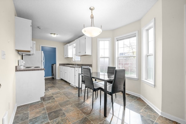 dining space with sink and a textured ceiling