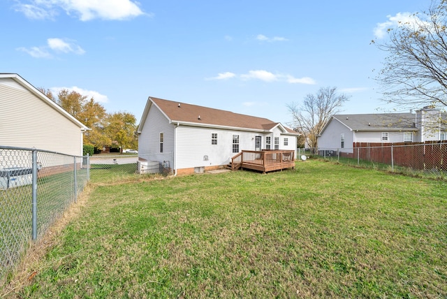 back of property with a lawn and a deck