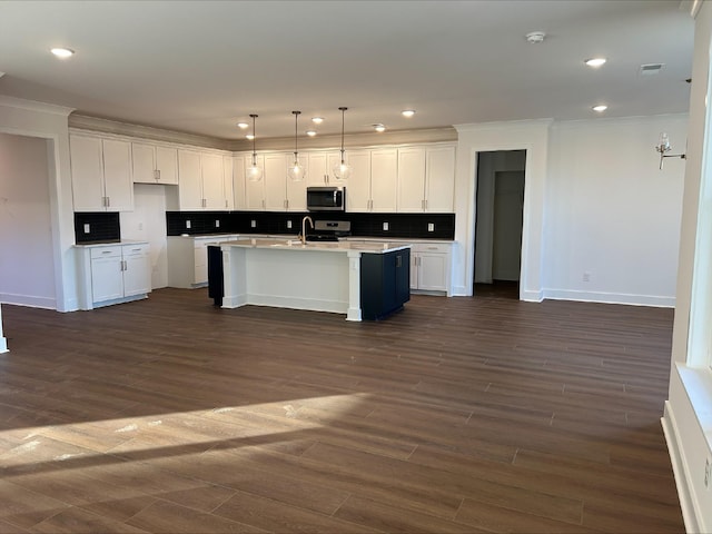 kitchen featuring an island with sink, pendant lighting, white cabinetry, and stainless steel appliances