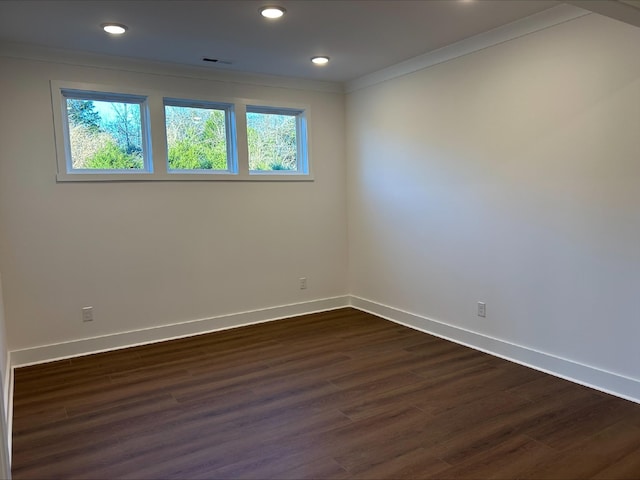 empty room with dark hardwood / wood-style floors and ornamental molding