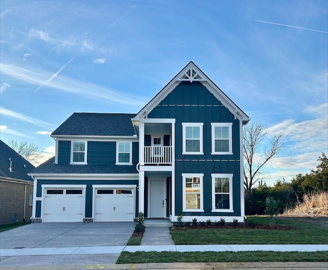 view of front of house featuring a garage, a front yard, and a balcony